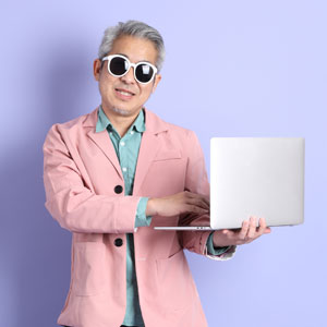 Mandarin man with laptop on purple background