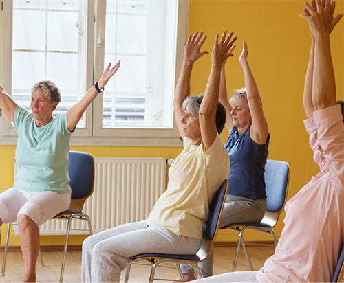 group doing yoga in chairs