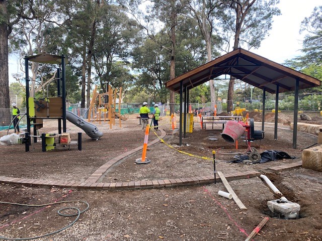outdoor playground under construction with workers in background