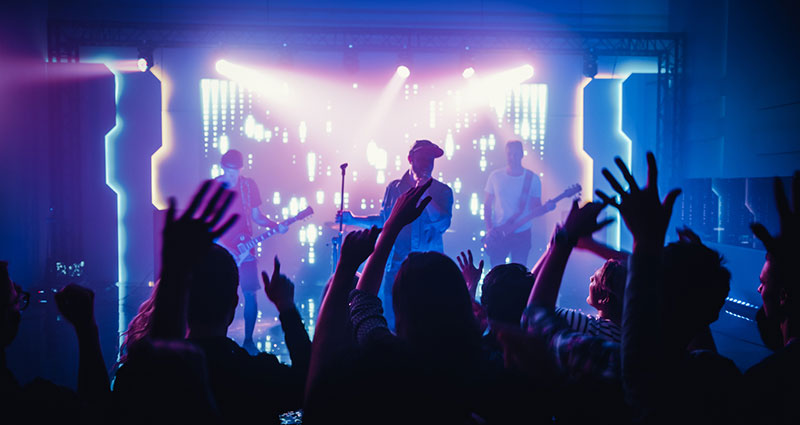 Rock Band with Guitarists and Drummer Performing at a Concert in a Night Club