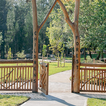 front view of park with trees and wooden gates