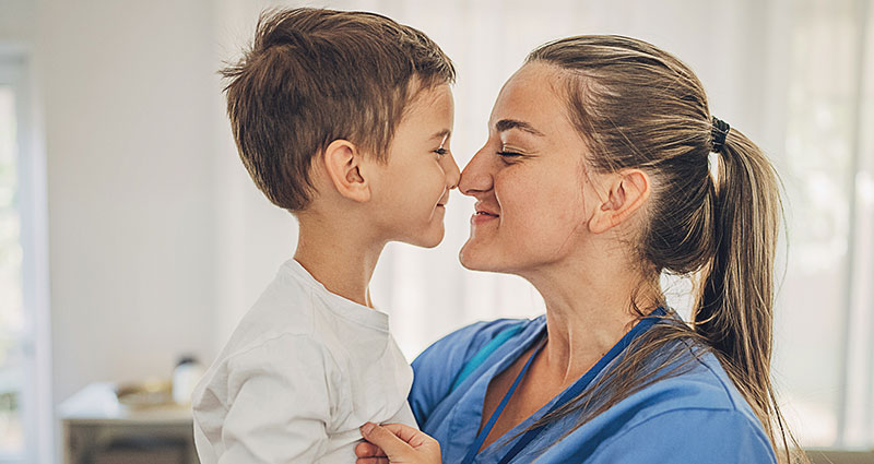 woman holding toddler in arms