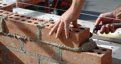 hands building brick wall